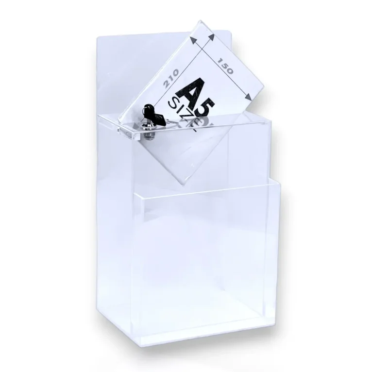 תיבת משוב/הגרלה מלבנית, עומדת על שולחן עם כותרת עליונה, מנעול ותא עלונים בחזית. עשויה פרספקס שקוף.