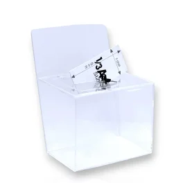 תיבת משוב/הגרלה טרפזית, עם כותרת עליונה ומנעול. עשויה פרספקס שקוף. מתאימה להנחה על שולחן.
